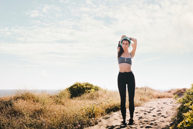 Mujer deportiva estirando brazos