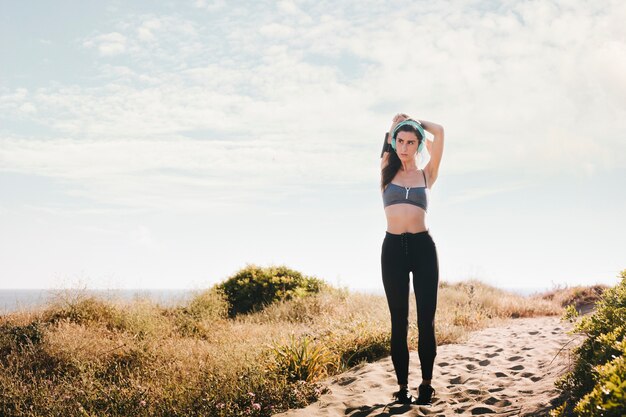 Mujer deportiva estirando brazos