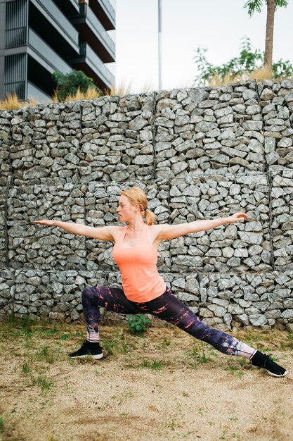 Mujer deportiva estirando en entorno urbano