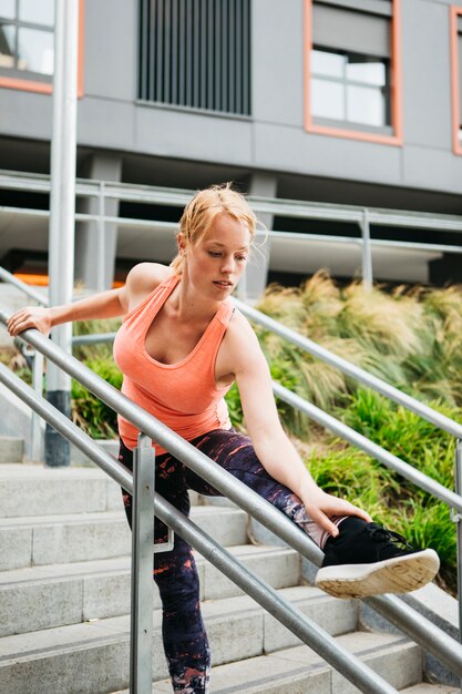 Mujer deportiva estirando en entorno urbano