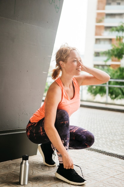 Mujer deportiva estirando en entorno urbano