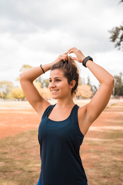 Foto gratuita mujer deportiva estirando en pista de estadio