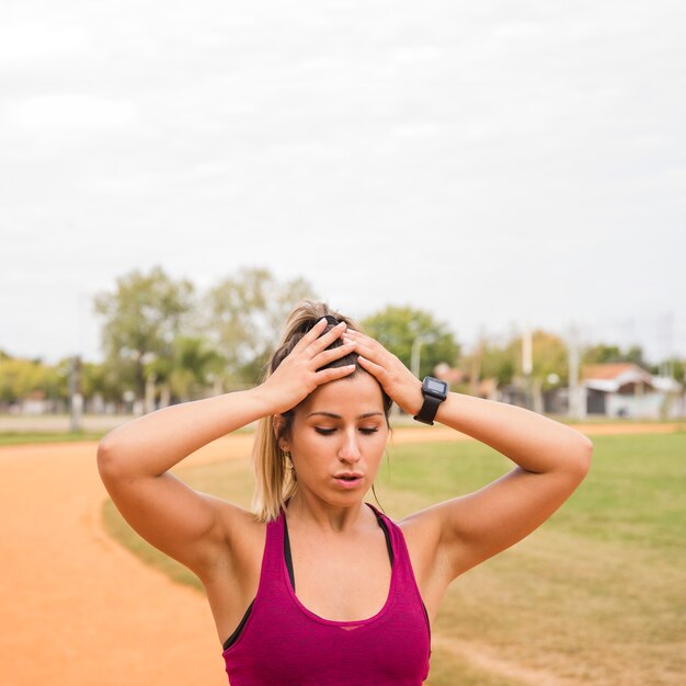 Mujer deportiva estirando en pista de estadio