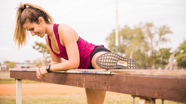 Foto gratuita mujer deportiva estirando en pista de estadio