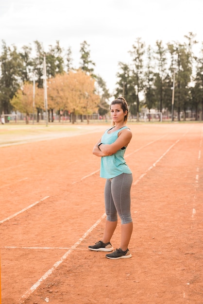 Mujer deportiva estirando en pista de estadio