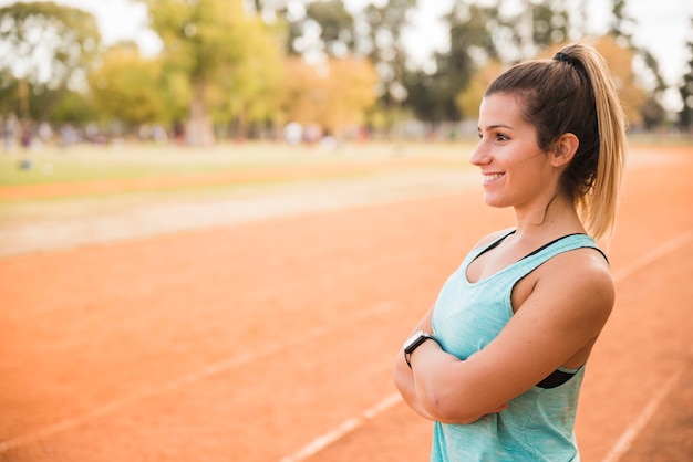 Mujer deportiva estirando en pista de estadio