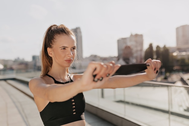 Mujer deportiva estirando sus brazos y mirando concentrado al aire libre en la ciudad