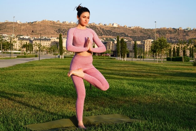 Mujer deportiva feliz practicando yoga al aire libre