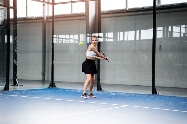 Mujer deportiva jugando al pádel tiro completo