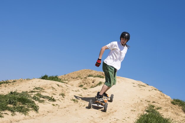 Mujer deportiva montando una tabla de montaña cuesta abajo