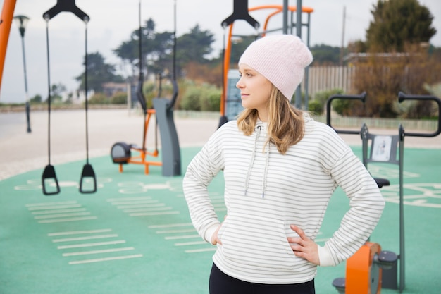 Mujer deportiva pensativa lista para entrenamiento al aire libre