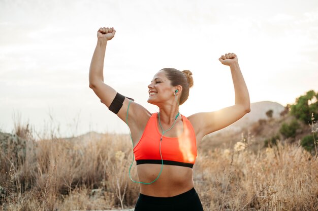 Mujer deportiva en pose de ganar