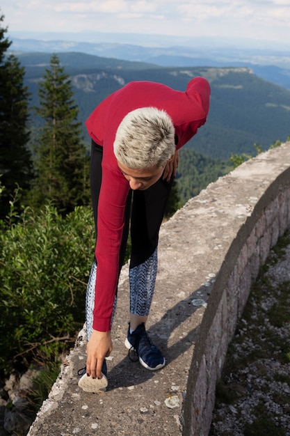 Foto gratuita mujer deportiva que se extiende en la naturaleza