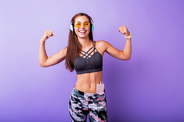 La mujer deportiva salida demuestra muscule en estudio.