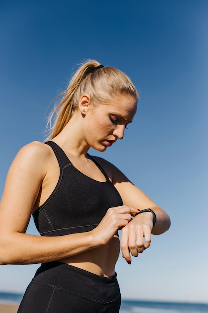 Mujer deportiva con smartwatch en la playa