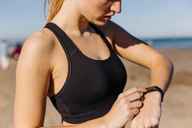 Mujer deportiva con smartwatch en la playa