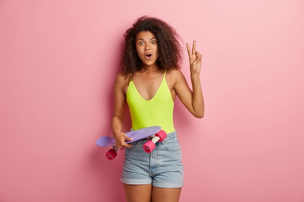 Mujer deportiva sorprendida posando con patineta