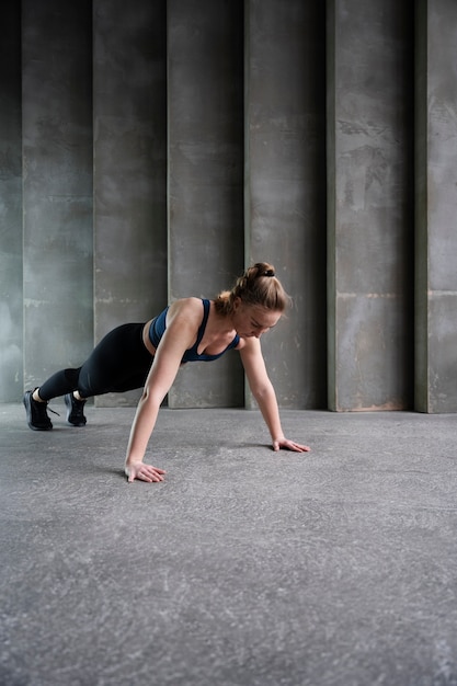 Mujer deportiva de tiro completo haciendo ejercicio dentro