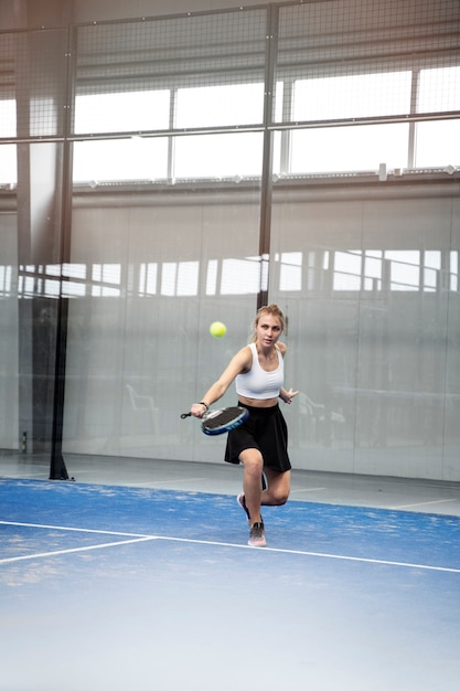 Mujer deportiva de tiro completo jugando al pádel