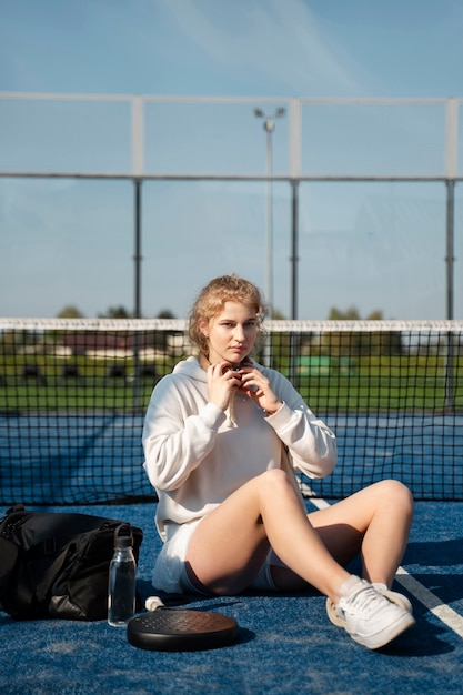 Mujer deportiva de tiro completo sentada