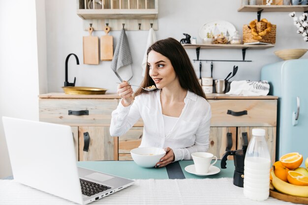 Mujer desayunando en la cocina