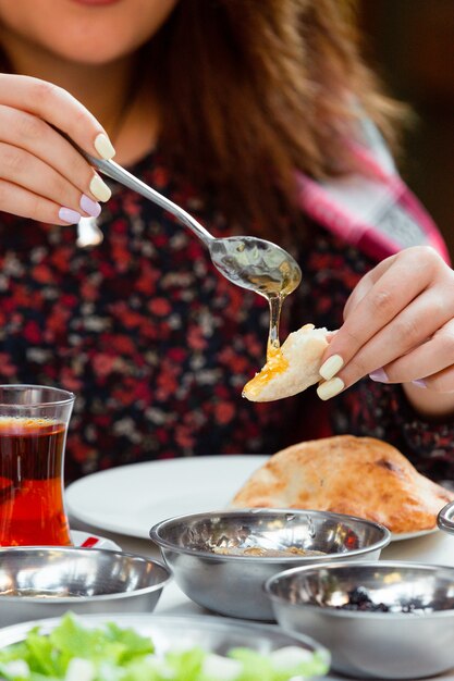 Mujer desayunar con pan y miel