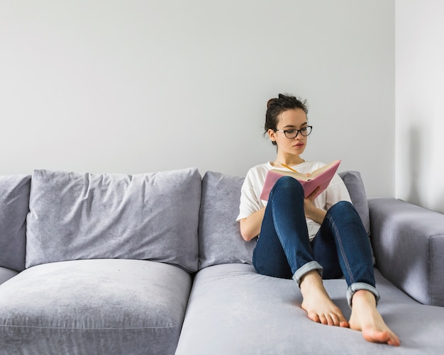 Foto gratuita mujer descalza escribiendo en libro