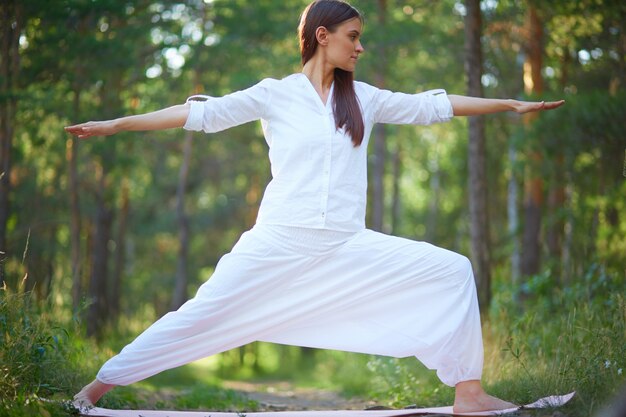 Mujer descalza estirando en la naturaleza