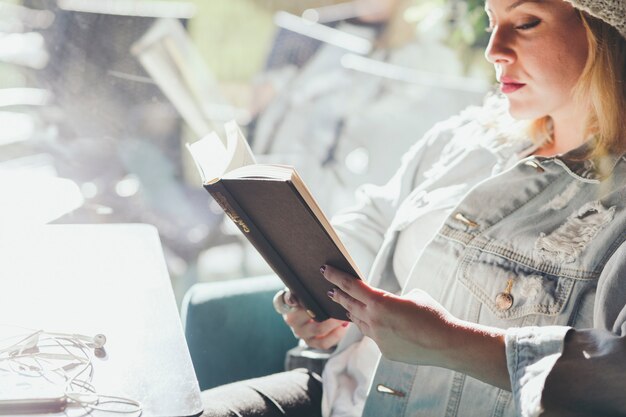 Mujer descansando con libro en café