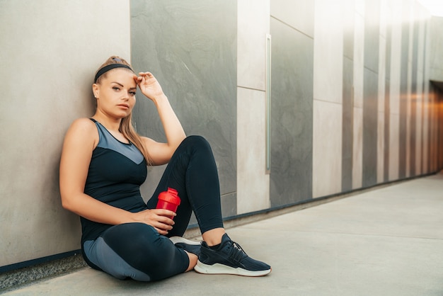 Foto gratuita mujer descansando en ropa deportiva