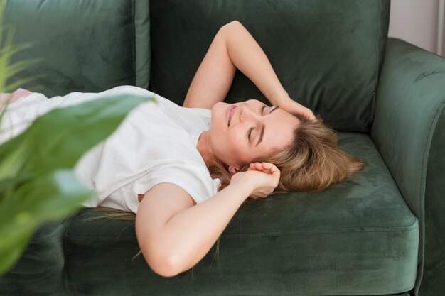 Mujer descansando en el sofá vista alta