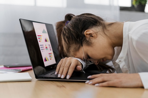 Foto gratuita mujer descansando su cabeza sobre un portátil