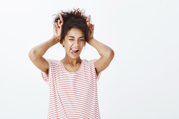 Mujer descarada con peinado afro posando en el estudio