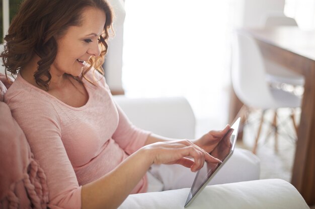 Mujer descubre nuevos sitios web interesantes por tableta digital