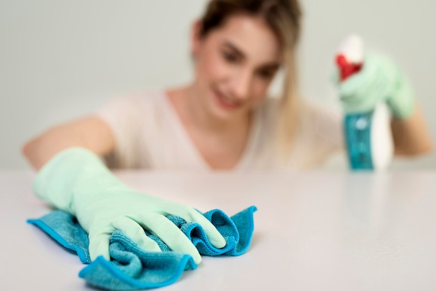 Mujer desenfocada con guantes de limpieza de superficie