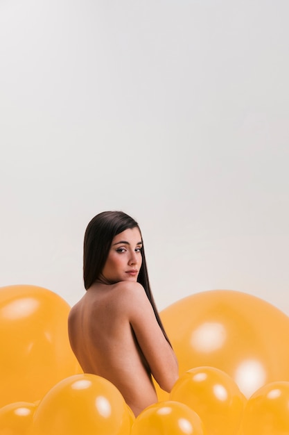 Mujer desnuda entra muchos globos amarillos