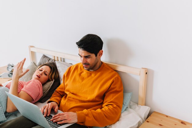 Mujer despertada por el hombre con la computadora portátil