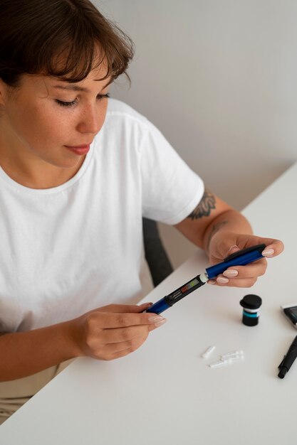 Mujer diabética de alto ángulo comprobando su nivel de glucosa