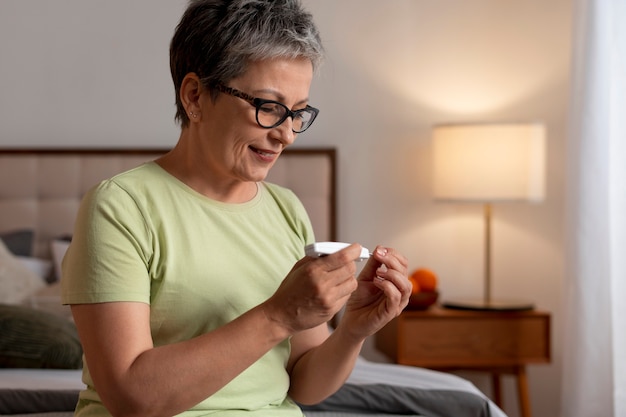 Mujer diabética de tiro medio comprobando su nivel de glucosa