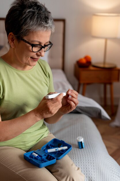 Mujer diabética de tiro medio comprobando su nivel de glucosa