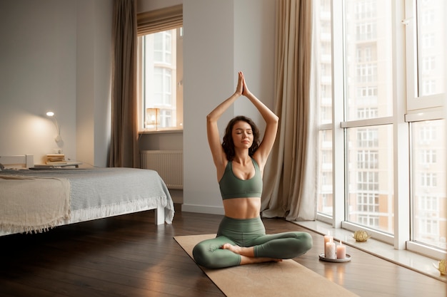 Mujer digital desconectándose en casa haciendo yoga