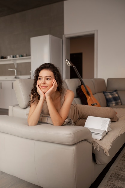 Mujer digital desconectándose en casa leyendo un libro