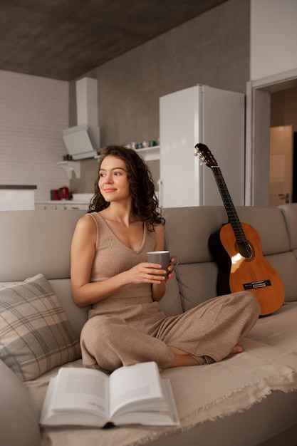 Mujer digital desconectándose en casa leyendo un libro