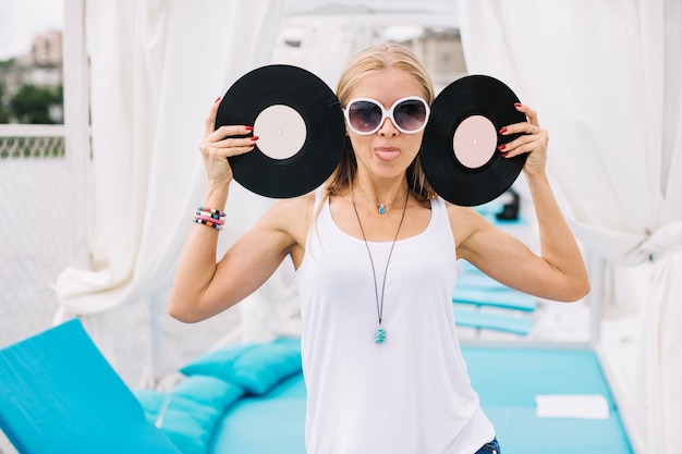 Foto gratuita mujer con discos de vinilo mostrando la lengua