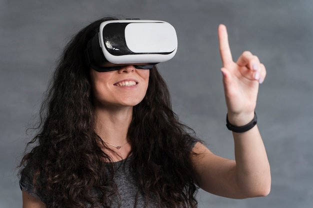 Mujer disfruta usando el vr y levantando una mano