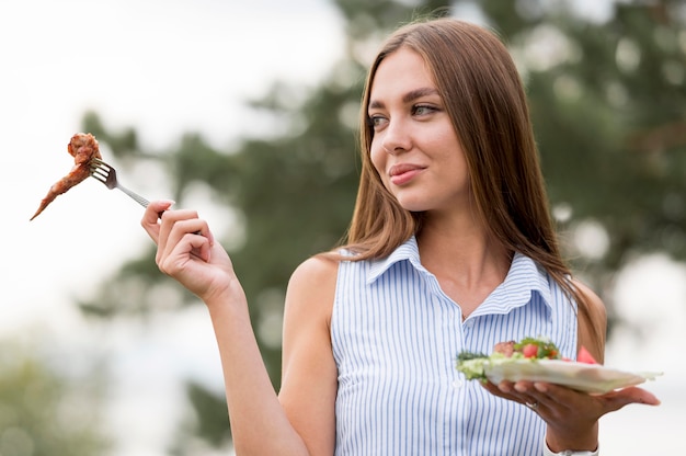 Mujer disfrutando de barbacoa al aire libre