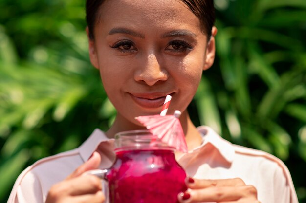 Mujer disfrutando de una bebida de fruta del dragón al aire libre