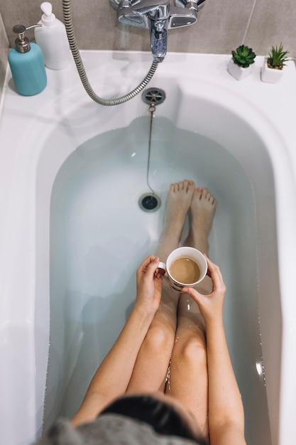 Mujer disfrutando de café en el baño