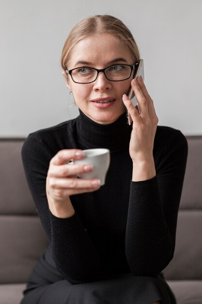 Mujer disfrutando de café y hablando por teléfono