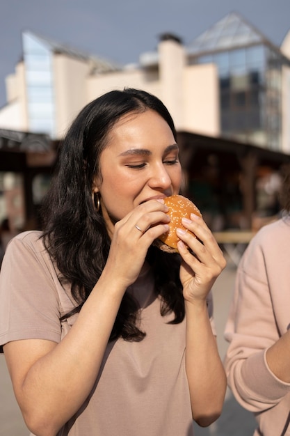 Foto gratuita mujer disfrutando de comida en la calle al aire libre